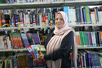 teacher holding books in the library
