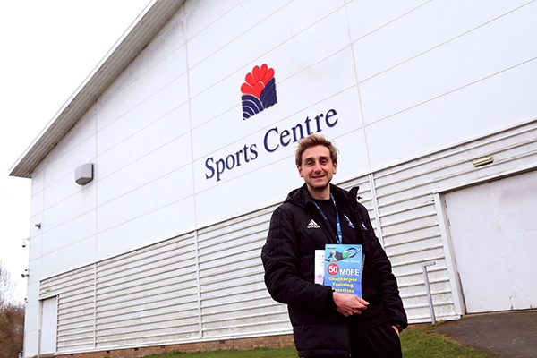sports lecturer in front of sports centre