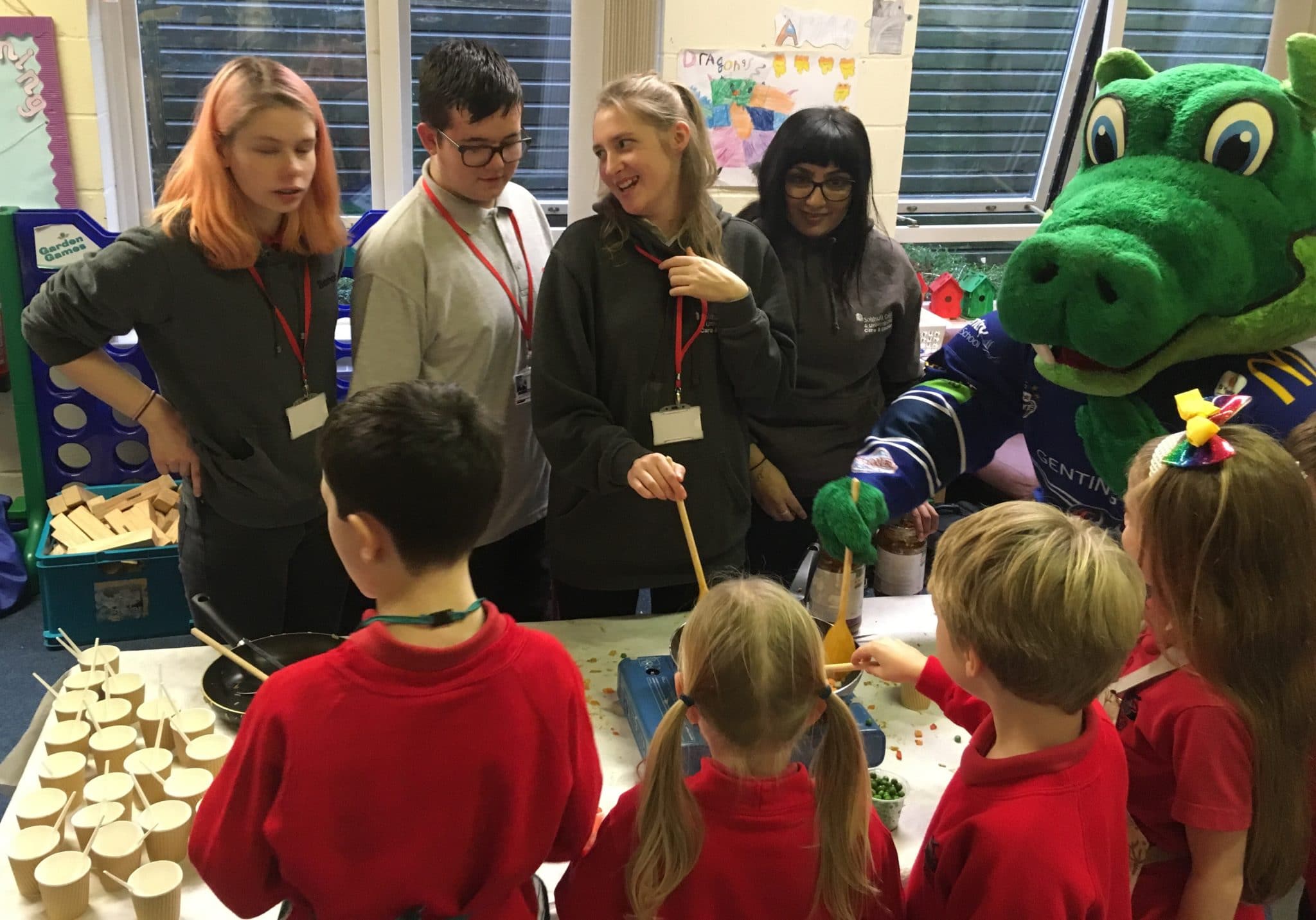 Students with the children and a mascot.