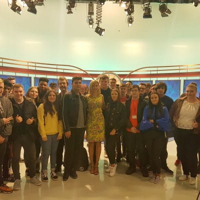 students standing with Rachel Riley