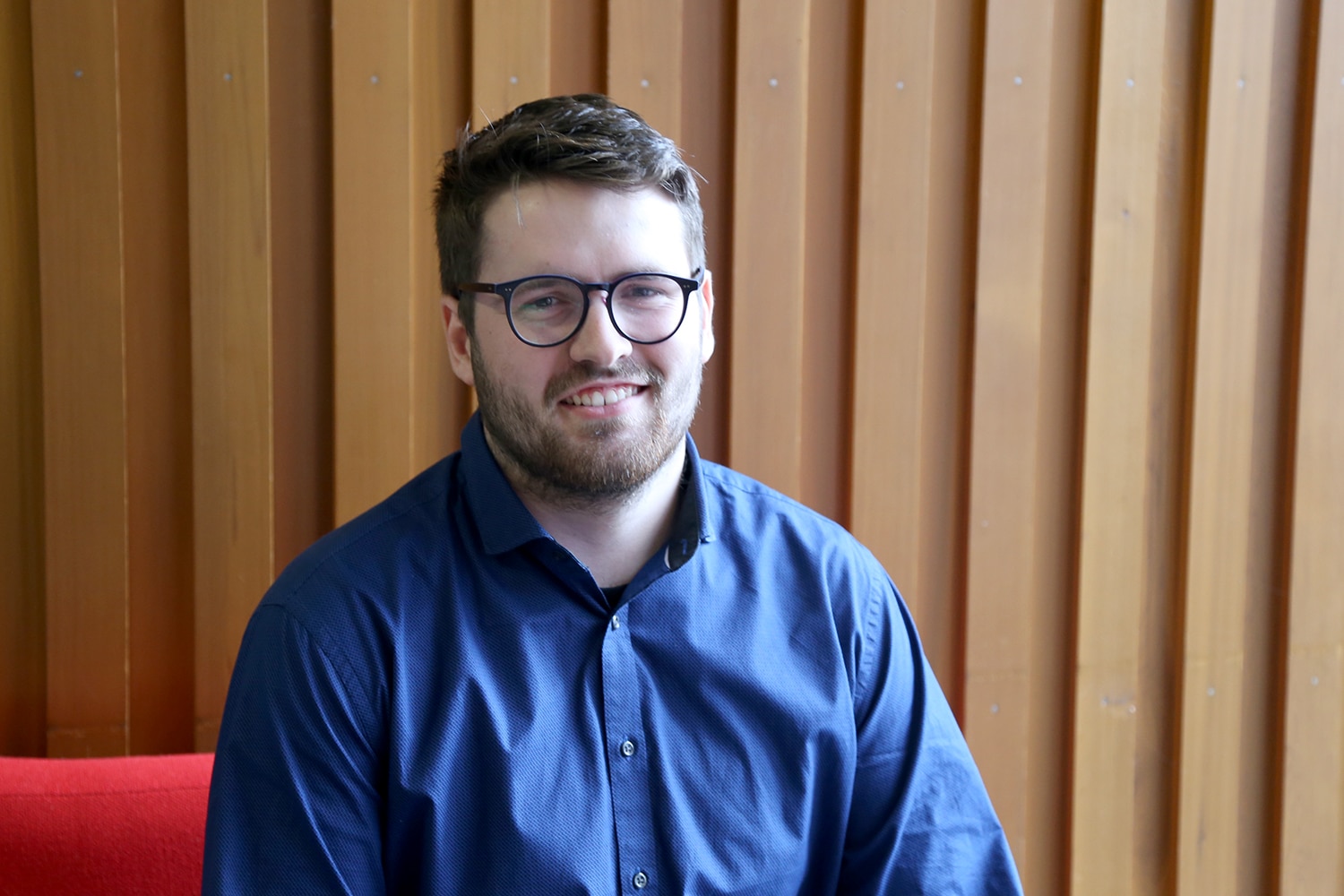 Student Oliver sits in reception of college.