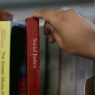 Student taking Social Justice book out.