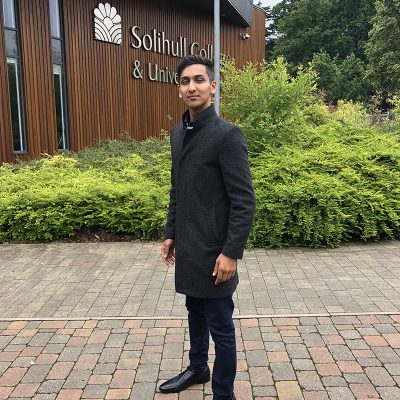 Nasim standing in front of college
