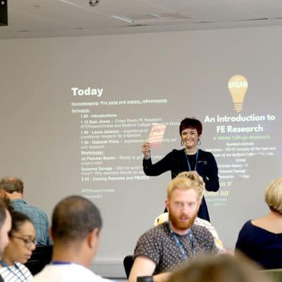 conference event speaker holding up a leaflet