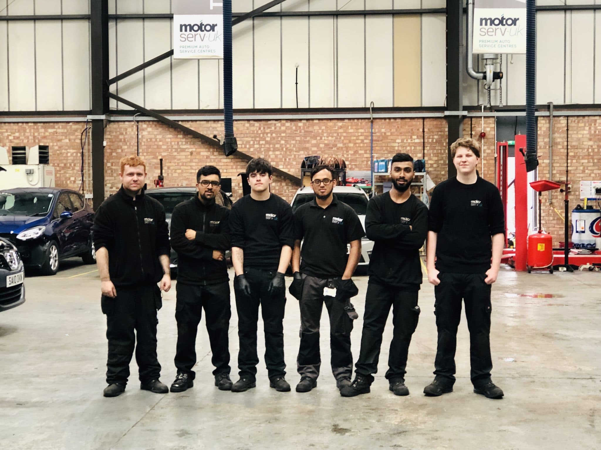Mechanics lined up in workshop