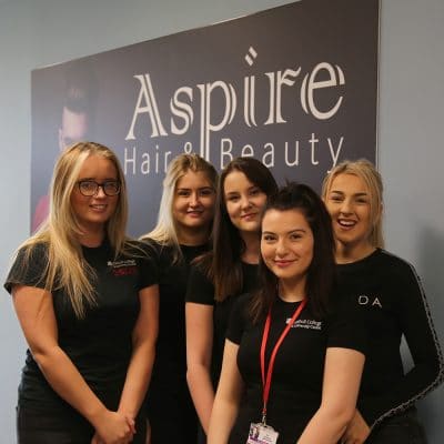 Hair & beauty students stood infront of aspire sign