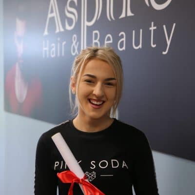 Hair & beauty student stood infront of aspire sign