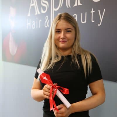 Hair & beauty student stood infront of aspire sign