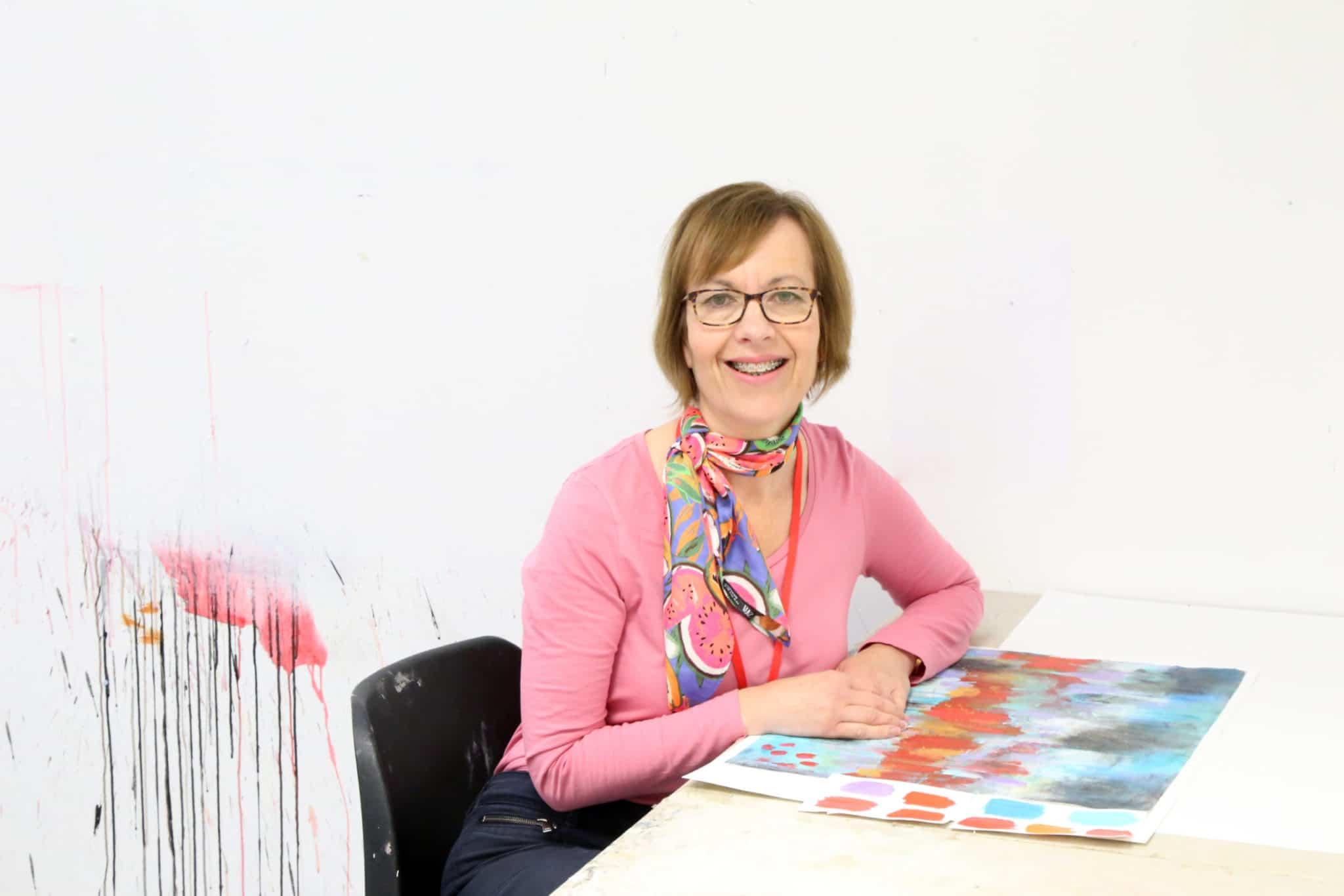 Art student sat with work at a desk