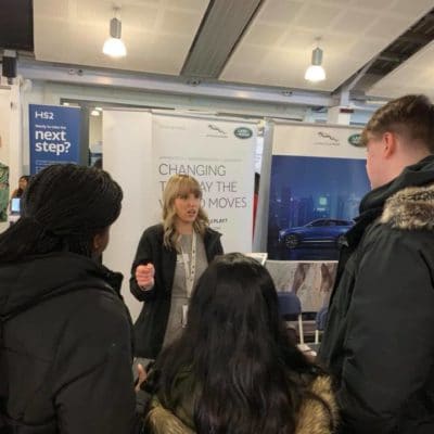 woman chatting with students at event