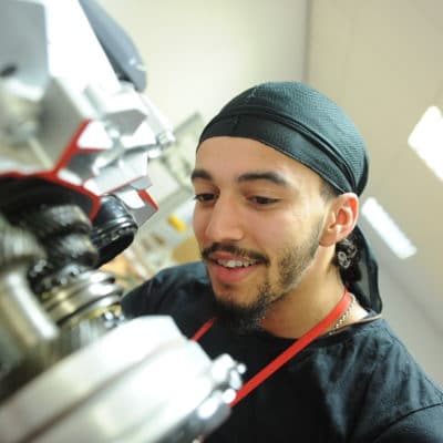 Student observes operation of engineering machine.