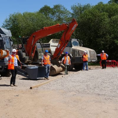 construction equipment with workers stood in front of it.