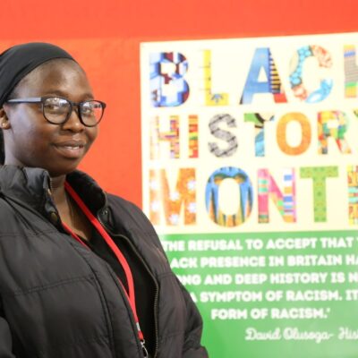 Student Fatima in front of a poster for Black History Month