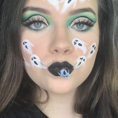 a student has painted small ghosts on her face