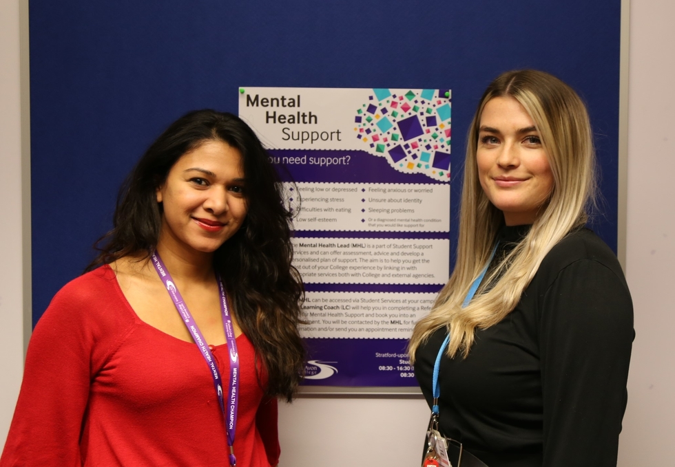 Fathima and Blair stand in front of a Mental Health Poster