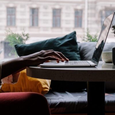 a laptop on a table with hands typing