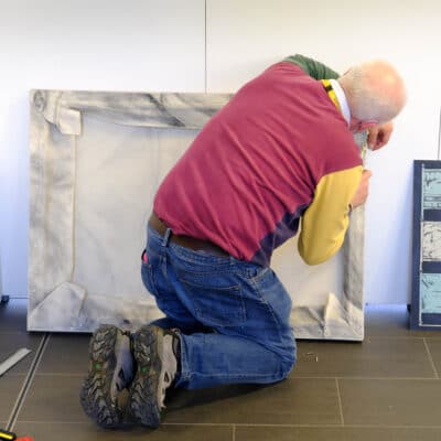 a male student gets a picture ready for display