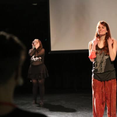 A young female performer looks out into the crowd.