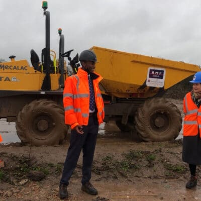 the group stand in front of plant on site