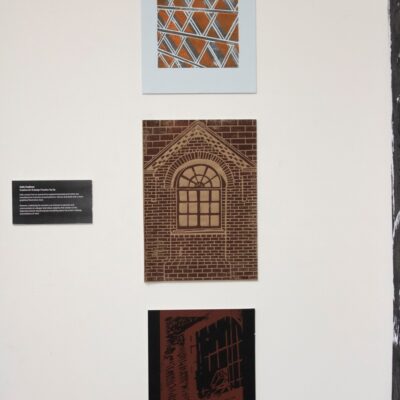 three drawings, a house in the middle, and architectural sketches up at the exhibition