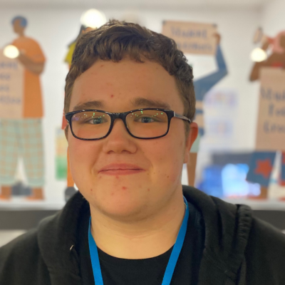 Tightly cropped face/shoulder shot of Will Pullen smiles at the camera