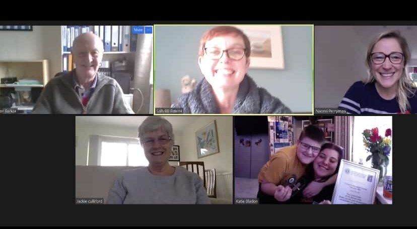 Katie on a zoom call winning her award with the judges and her brother.