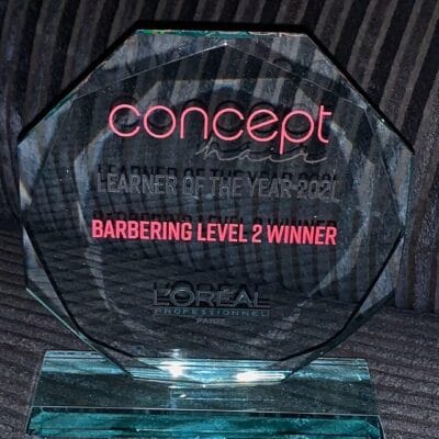Lauren's glass award with her title Barbering Level 2 winner on the front.