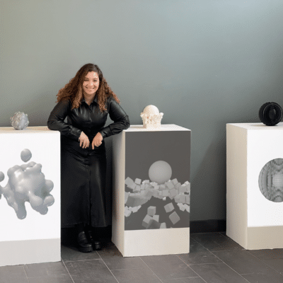 an artist stood with her models on plinths