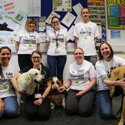 The College team all in Dogs Home Tshirts stood with three dogs in a classroom