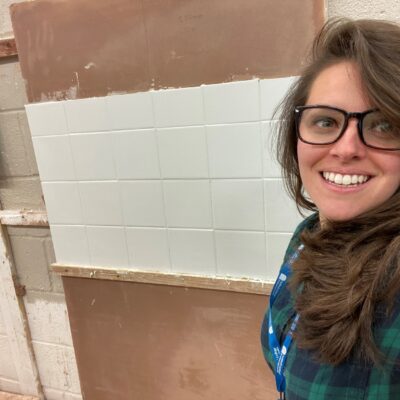 Teacher Rachel stood in front of her tiling effort.