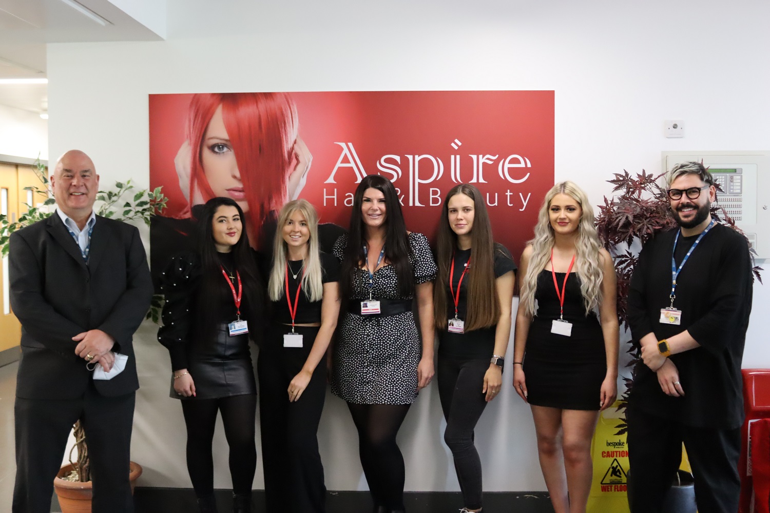 The apprentices stood with tutors and the Principle in front of the Aspire sign