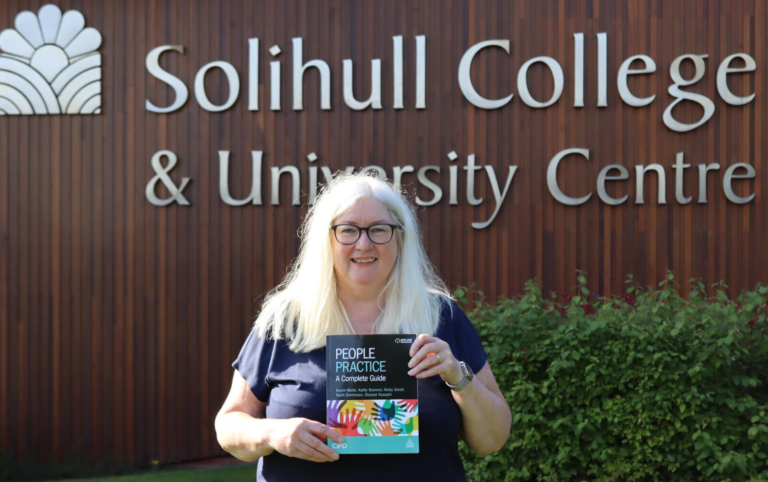 Nicky poses with the book outside the College entrance.