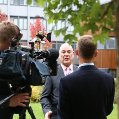 John in front of TV cameras