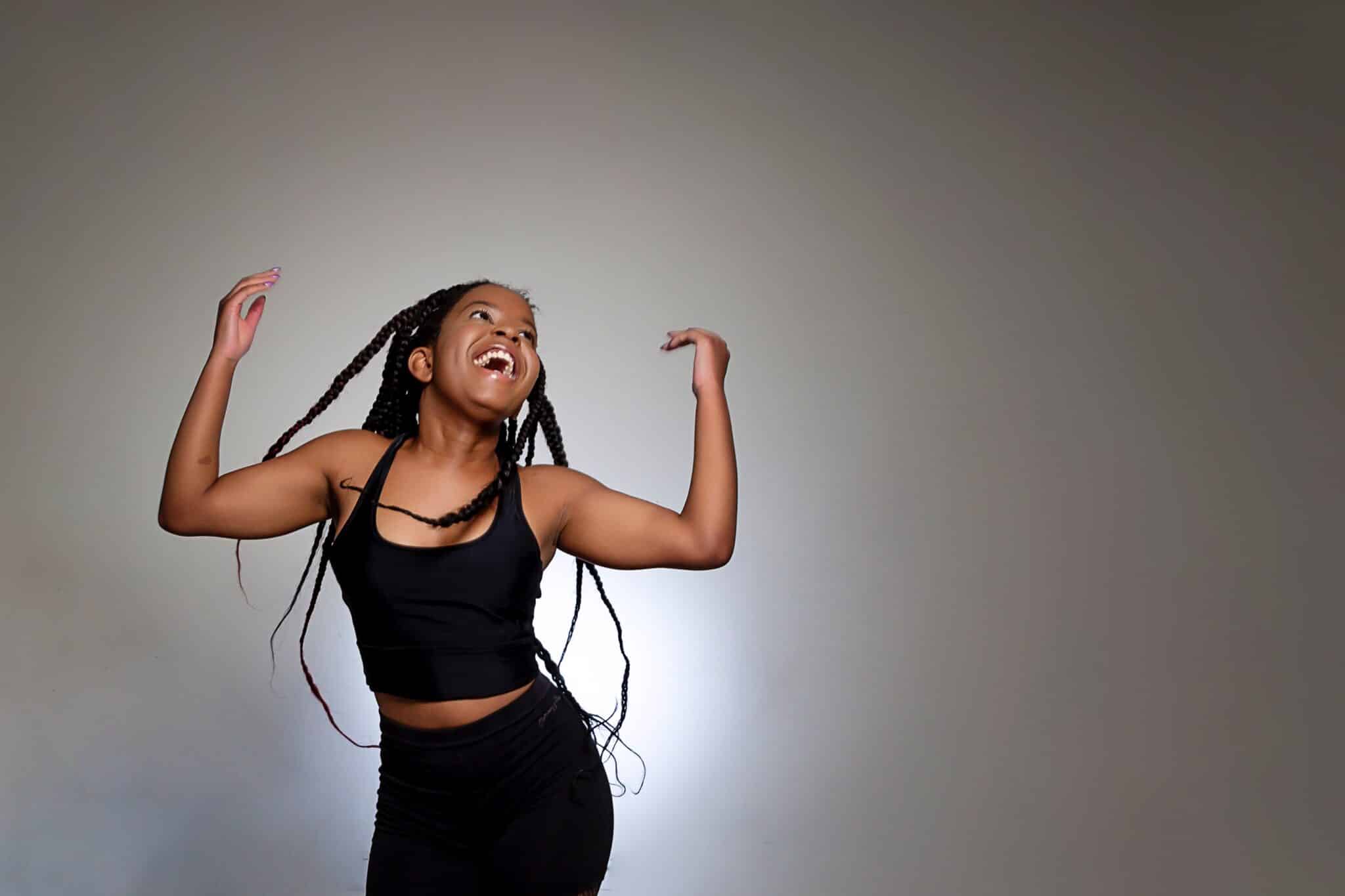 student flicking her hair with arms in air