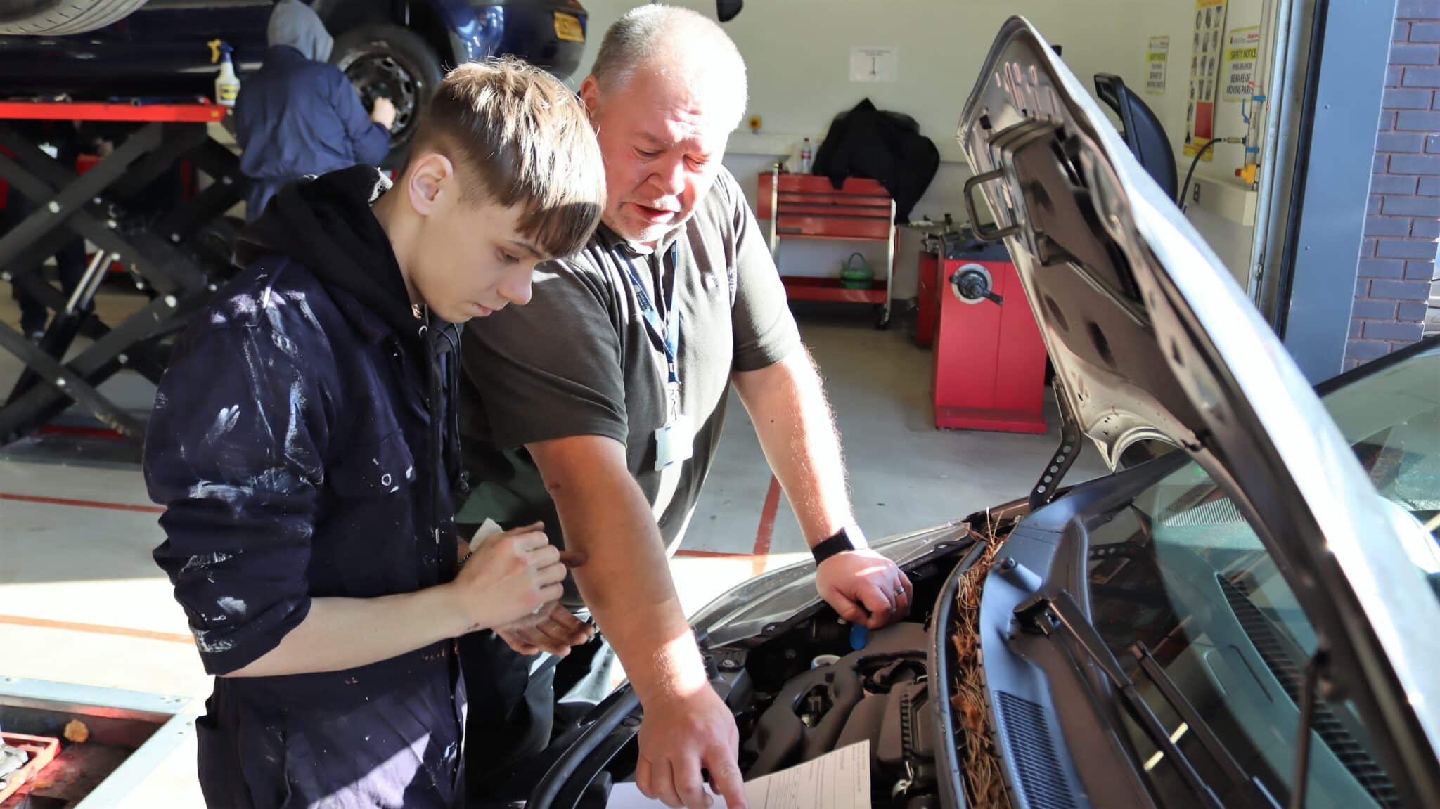 tutor showing student something in car
