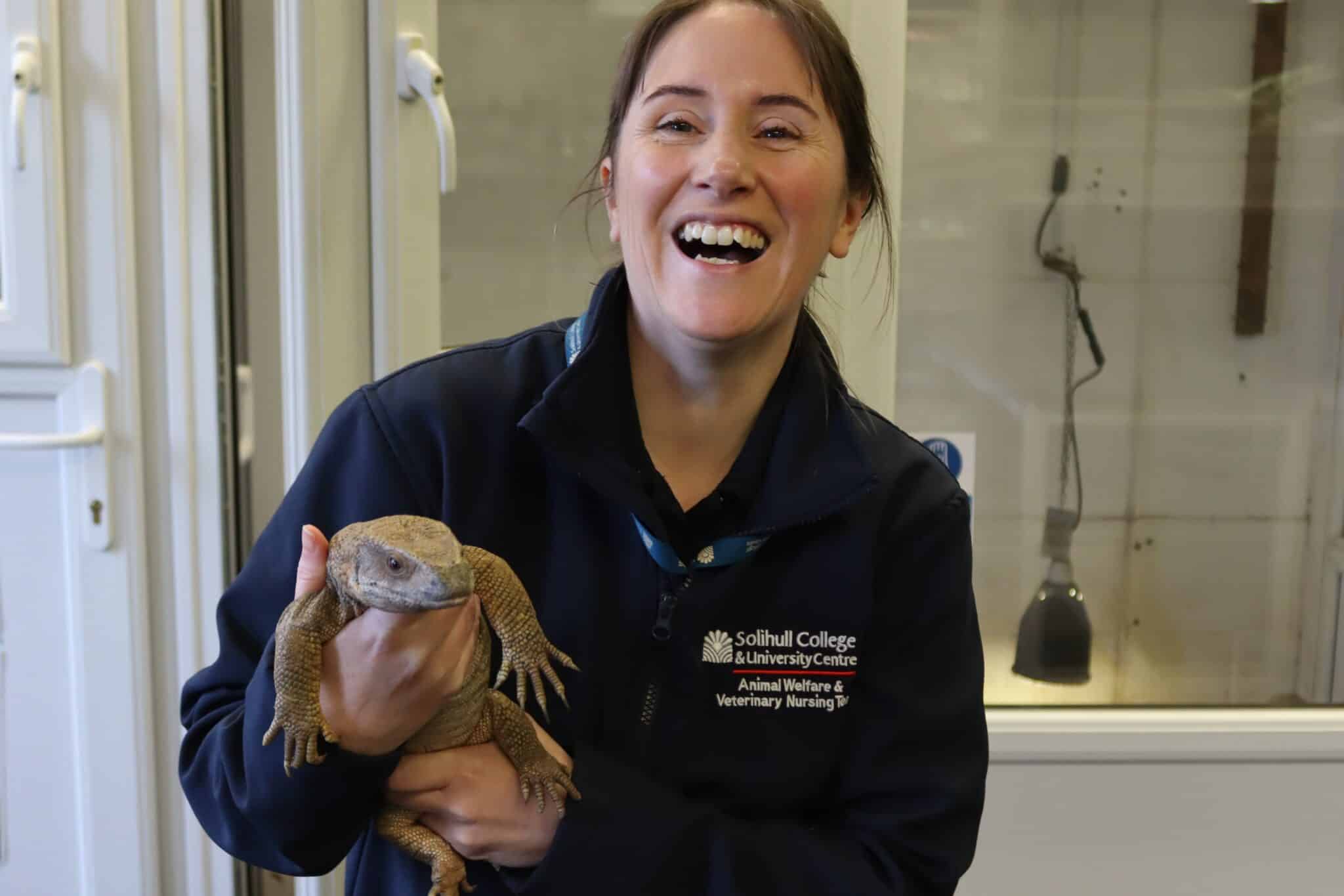 Tutor holding lizard and smiling