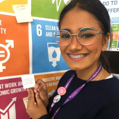 staff member in front of SDGs display board