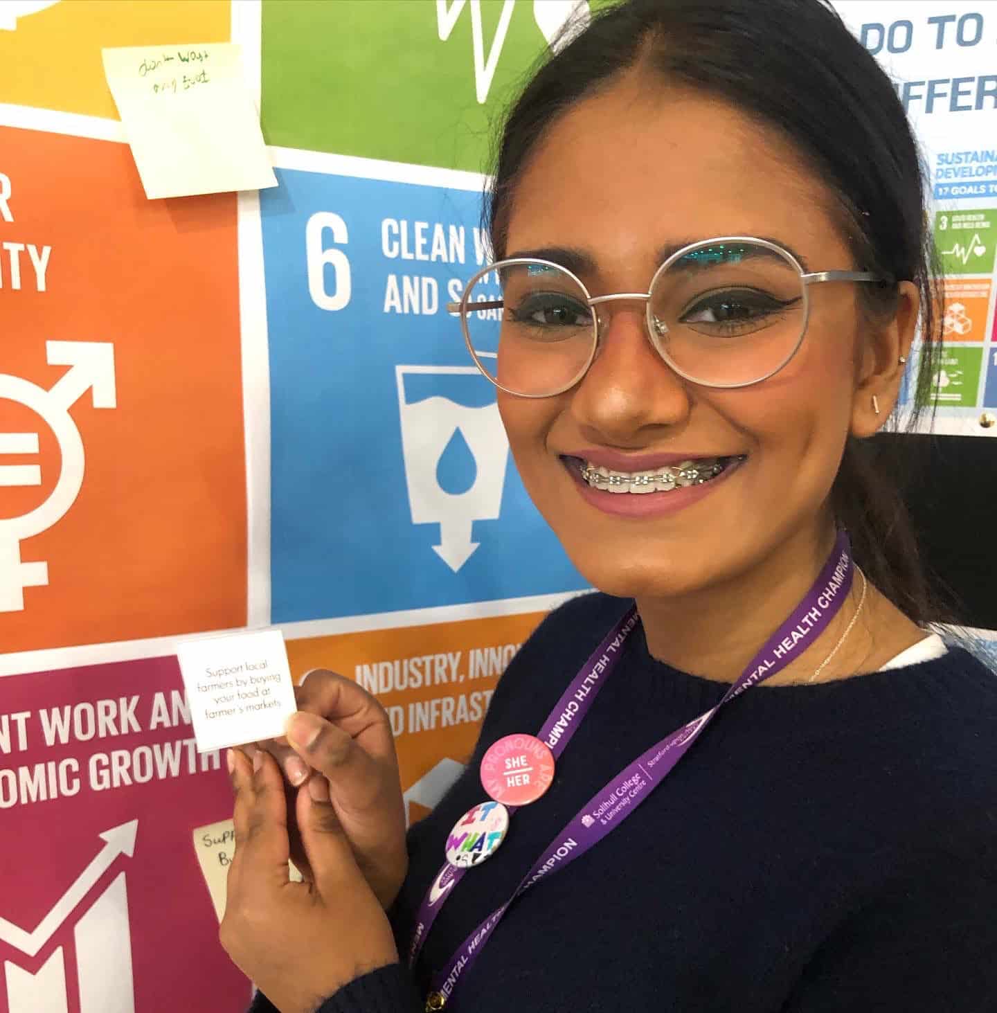 staff member in front of SDGs display board