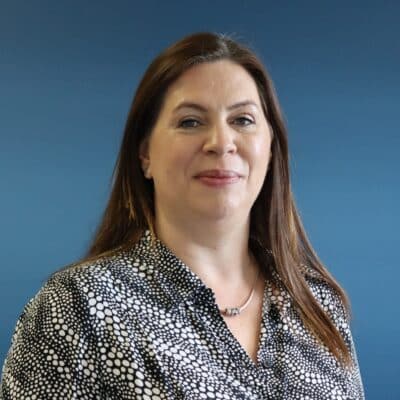 Blue Background, Rebecca standing wearing a black and white patterened top