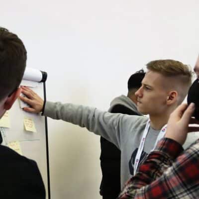 Students sticking post-it notes to whiteboard