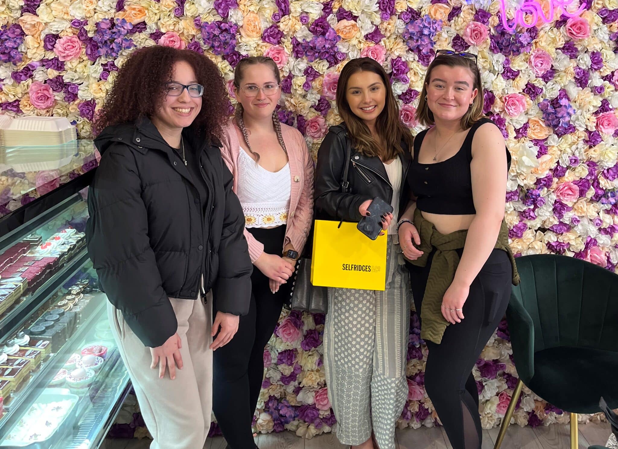 Make up students against flower wall