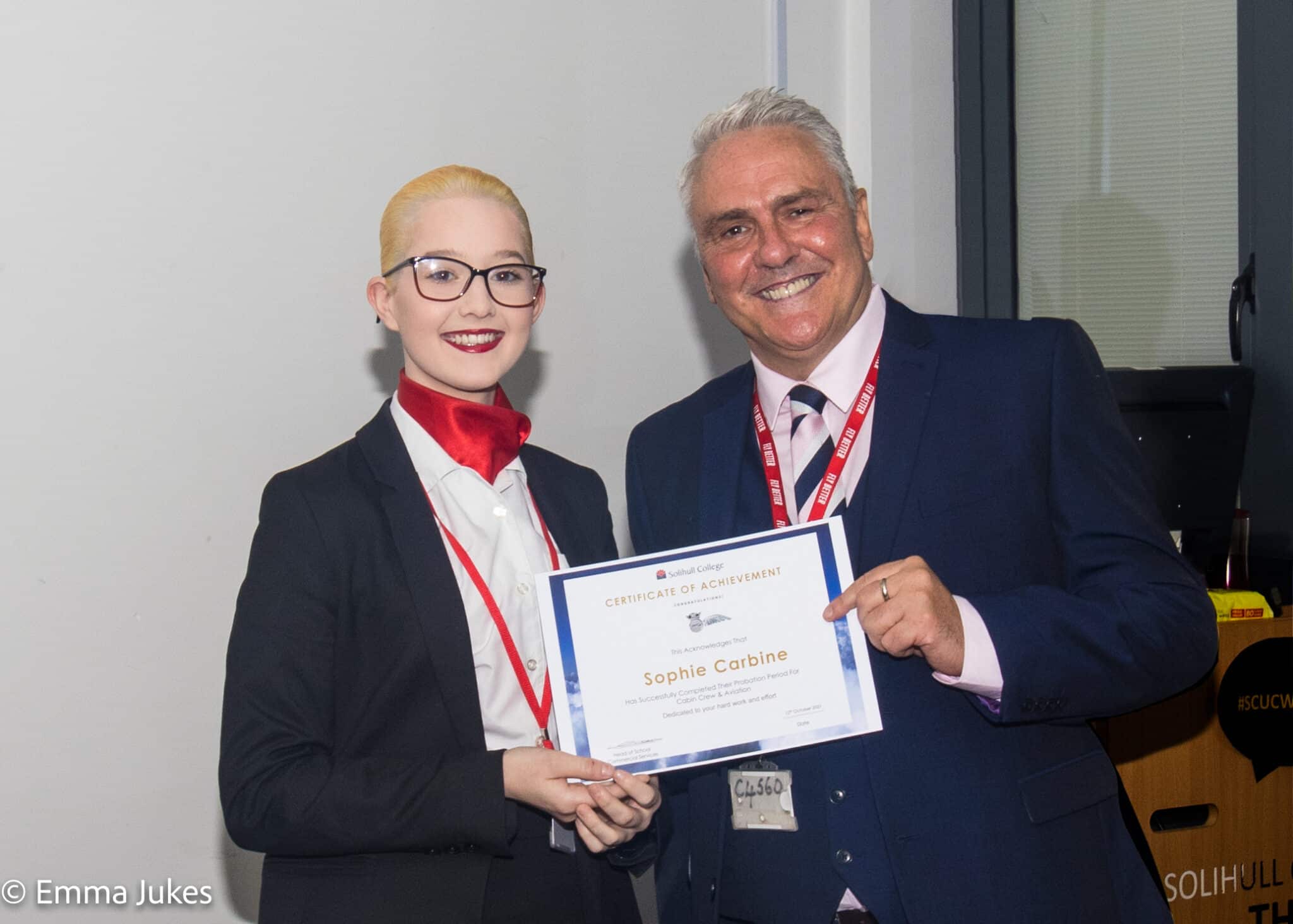 Student standing next to tutor holding certificate