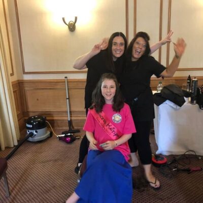 2 women waving arms and child sitting on chair