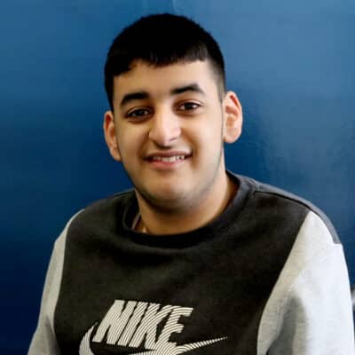 Student looking at camera with blue background