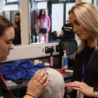 Teacher showing student how to use bald cap