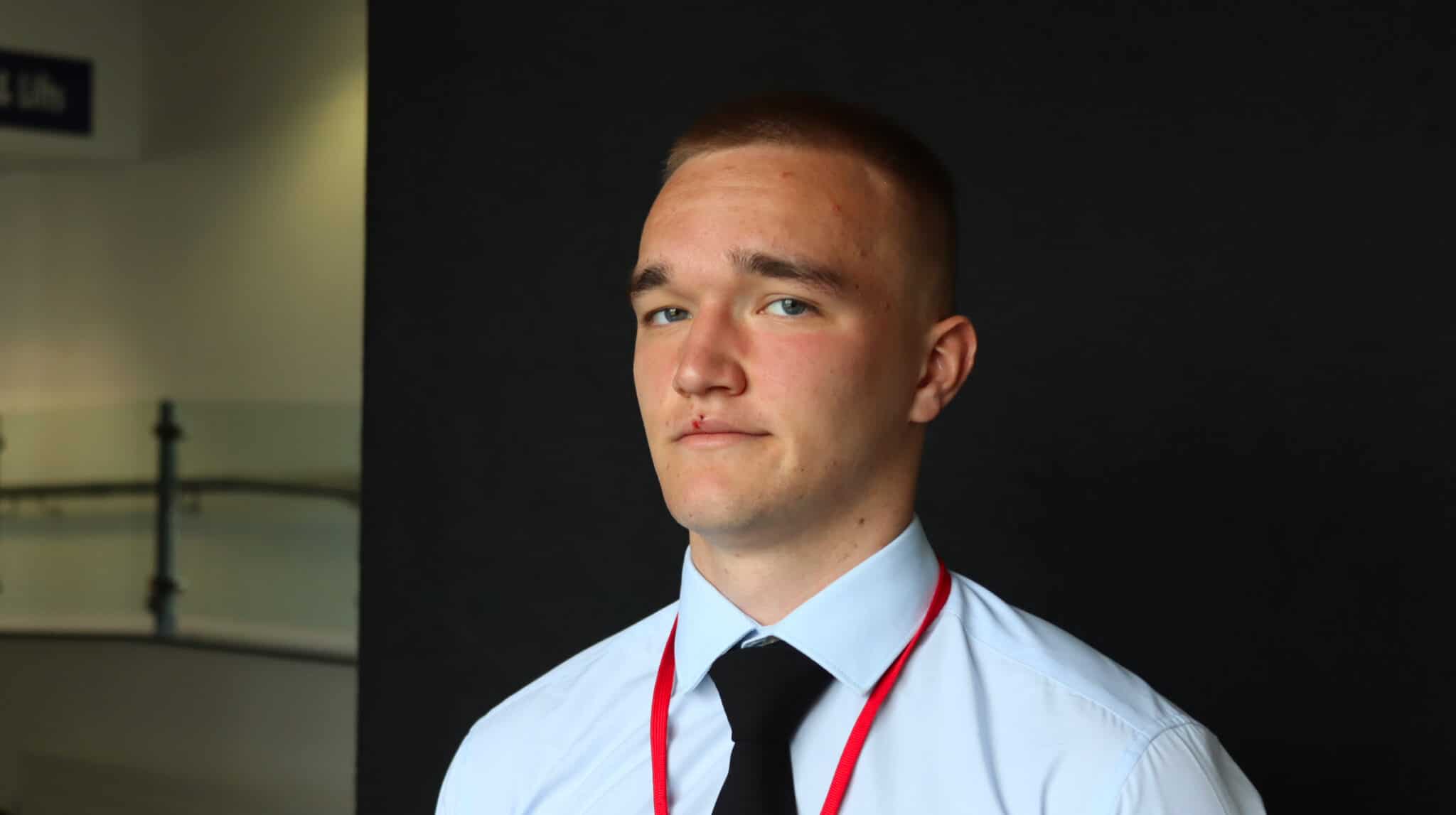 student looking at camera with black background