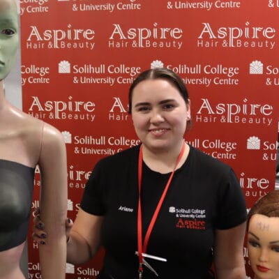 Student with two mannequins and Aspire background