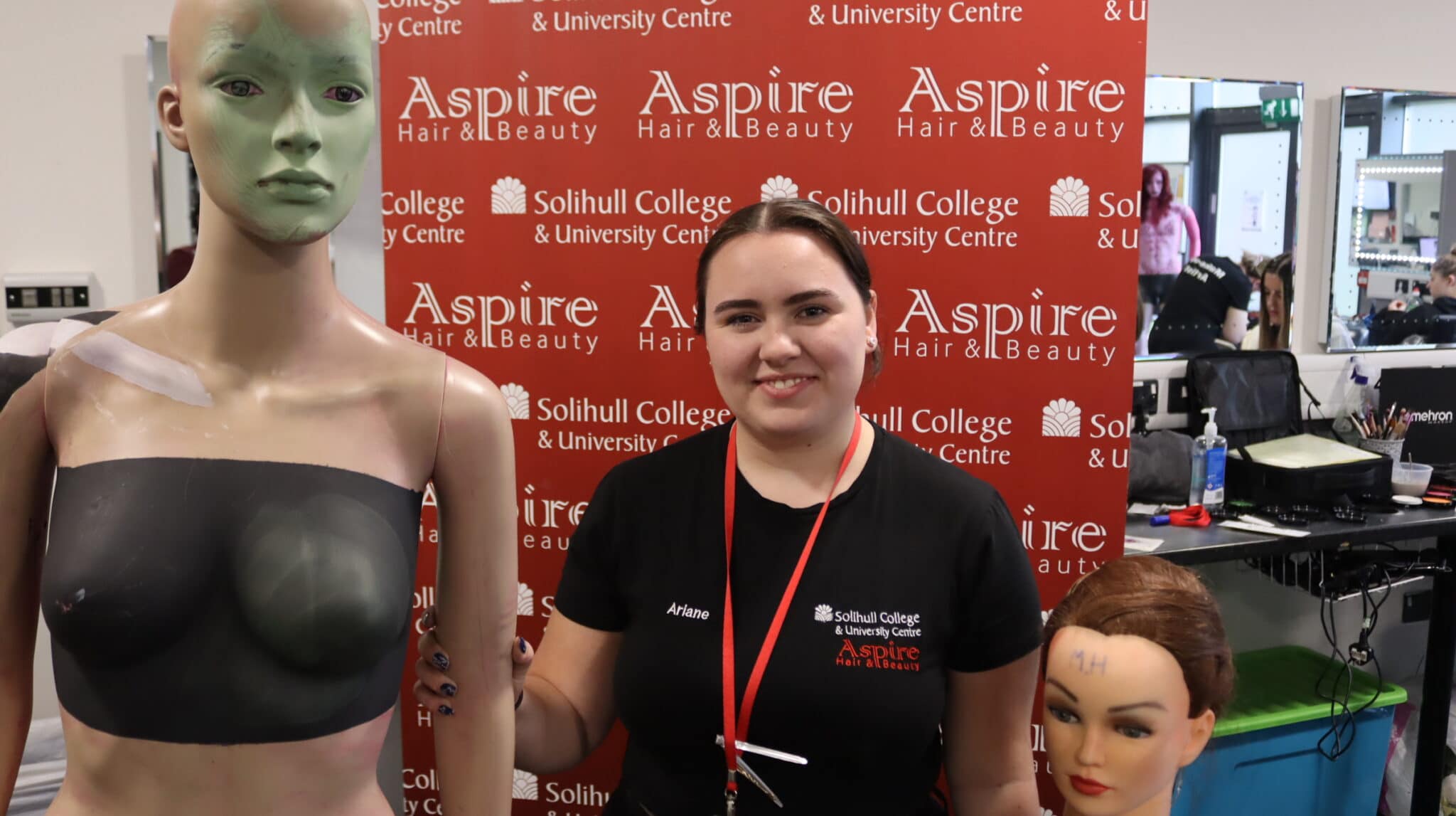 Student with two mannequins and Aspire background