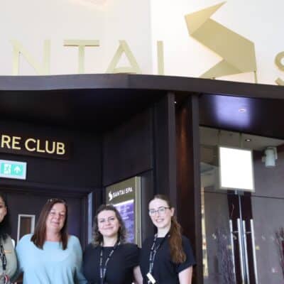 3 students standing with lecturer in front of Santai Spa