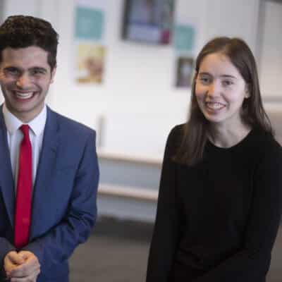 Two students looking at camera smiling